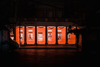 Illuminated building by street at night