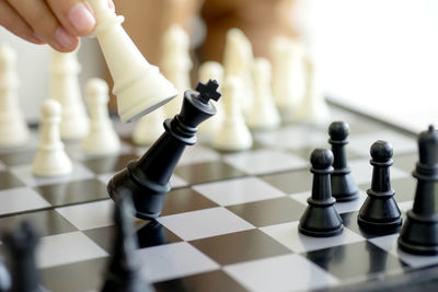 Cropped hand playing chess at home