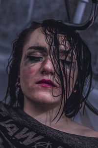 Close-up of young woman with messy face in bathtub