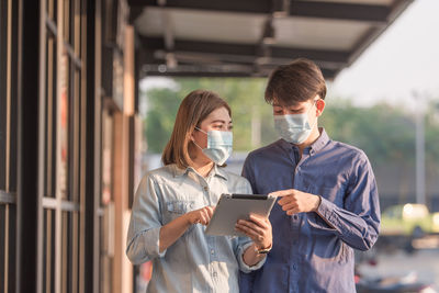 Couple wearing mask discussing while standing outdoors