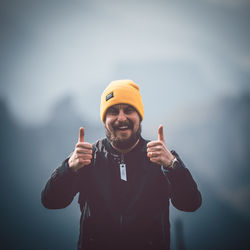 Portrait of smiling man standing against sky