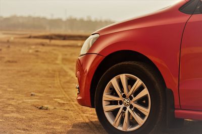 Close-up of red car on dirt road