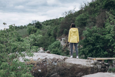 Rear view of person walking on rocks