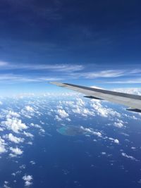 Aerial view of airplane wing against blue sky