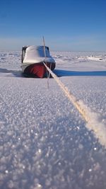 Man on snow covered land against sky