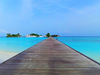 Pier over sea against blue sky