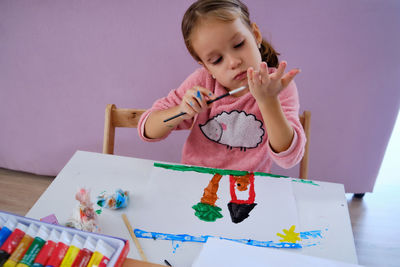 High angle view of boy drawing on table