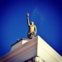 Low angle view of statue against clear blue sky