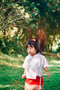 Portrait of young woman standing against plants