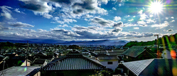 Aerial view of townscape against sky on sunny day