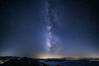 Scenic view of snowcapped mountains against sky at night