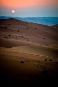 Scenic view of desert against sky during sunset