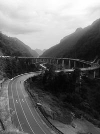 Scenic view of road by mountain against sky