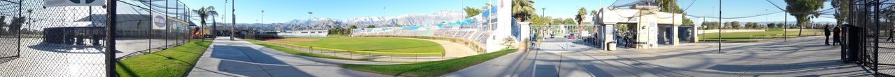 Panoramic view of stadium by street during sunny day