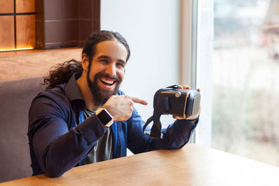 Portrait of smiling young man sitting on table