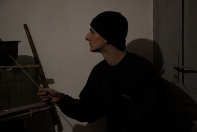 Side view of young man standing at home