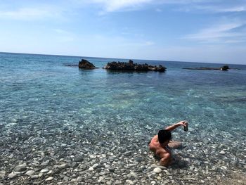 Man in sea against sky