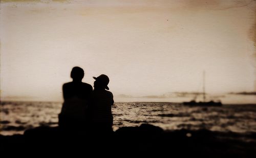 Woman standing on beach at sunset