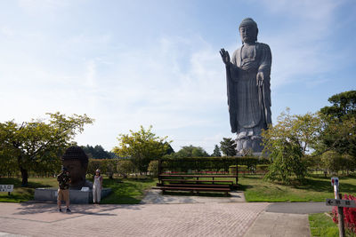 Statue by trees against sky