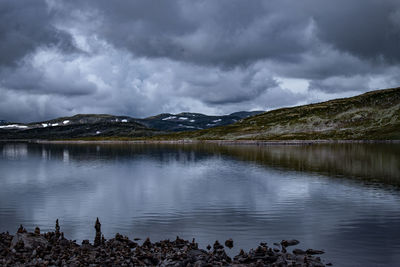 Scenic view of lake by mountains against sky