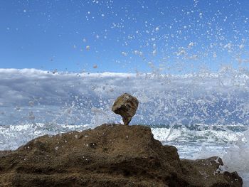 Rock formation on beach against sky