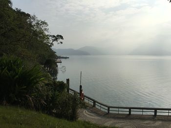 Scenic view of swimming pool by lake against sky