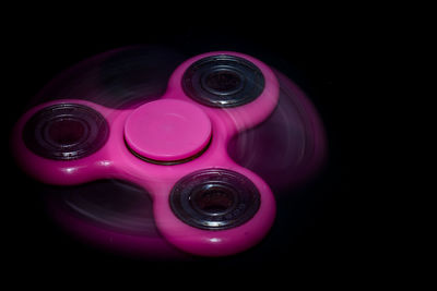 High angle view of pink camera over black background