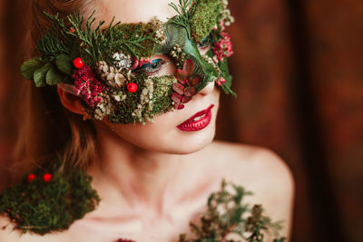 Close-up of woman with flower mask looking away