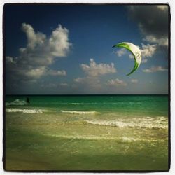 Scenic view of beach against cloudy sky