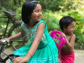 Happy siblings playing on tree