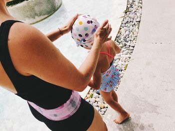 Midsection of mother with daughter standing on footpath