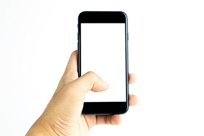 Close-up of hand holding mobile phone over white background