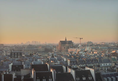 Buildings in city against sky during sunset