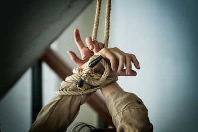 Midsection of person holding rope