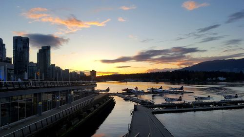 Boats moored at harbor during sunset