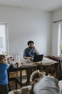 Man working from home and taking care of children