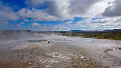 Scenic view of beach against cloudy sky