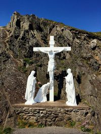 Cross on mountain against blue sky