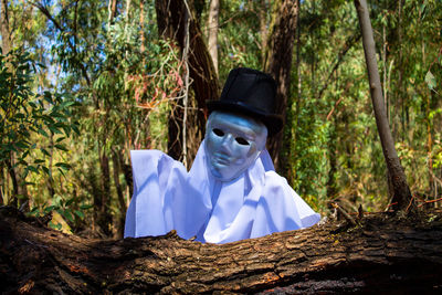 Portrait of man against tree trunk in forest