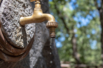 Low angle view of old faucet against trees