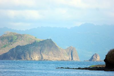 Scenic view of sea and mountains against sky