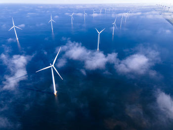 Wind turbines on landscape against sky