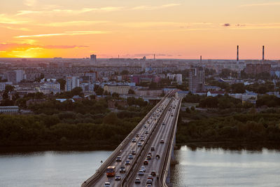 High angle view of river amidst buildings against sky during sunset