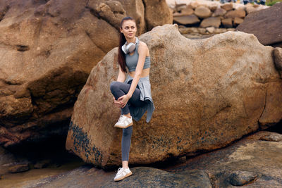 Rear view of man sitting on rock