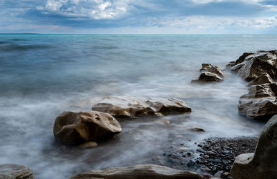 Rocks in sea against sky