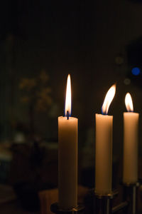 Close-up of lit candles in darkroom