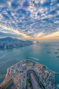 Aerial view of city buildings against cloudy sky