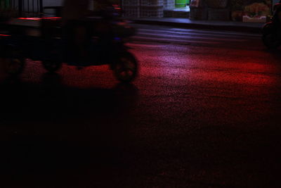 Low section of person riding motorcycle on road at night