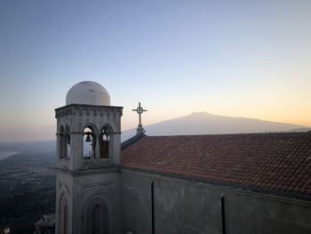 View of church and building against sky during sunset