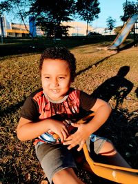 Portrait of boy sitting on field